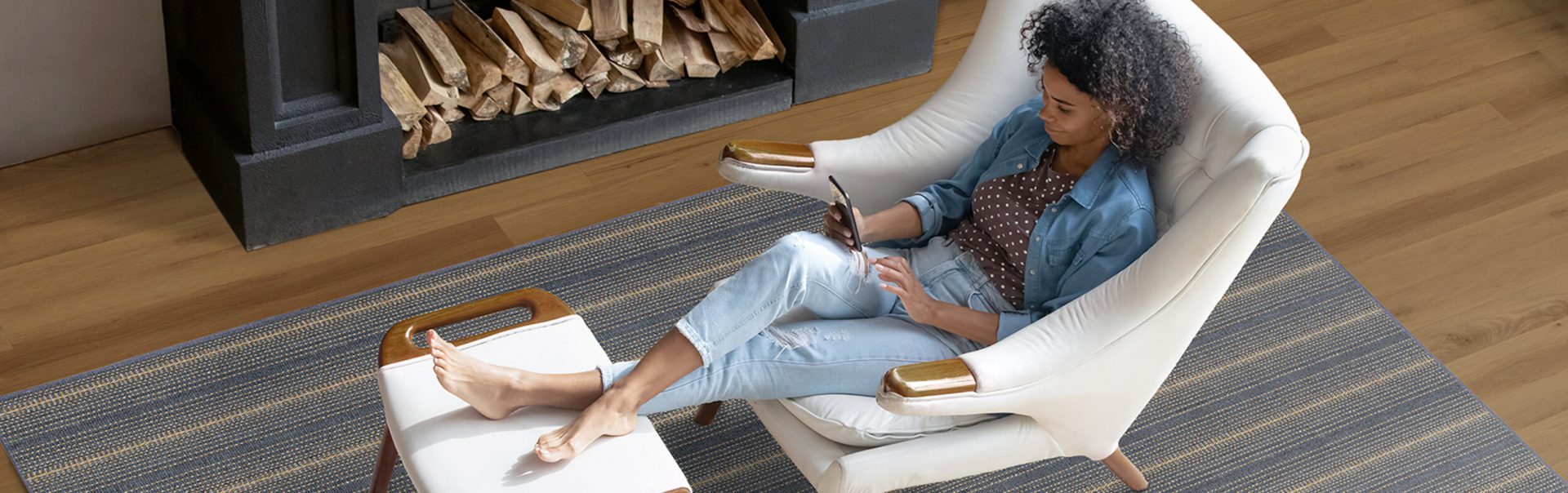 A woman relaxing in her livingroom, while looking at her phone.